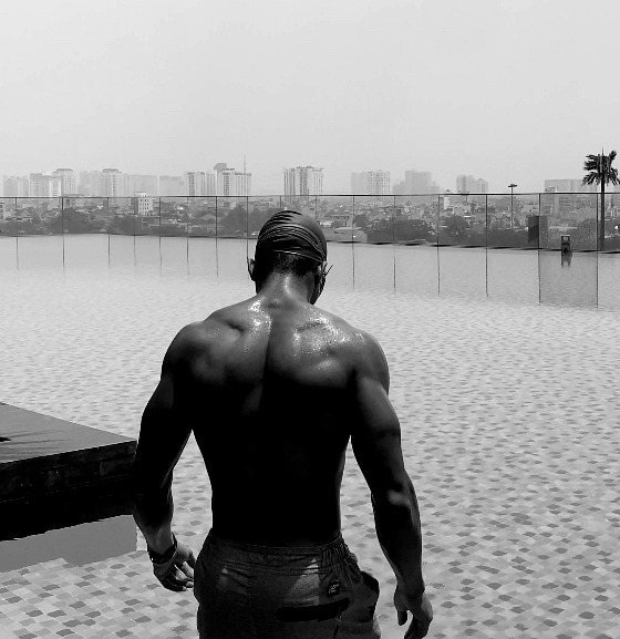 Back view of a figure standing beside an infinity pool.