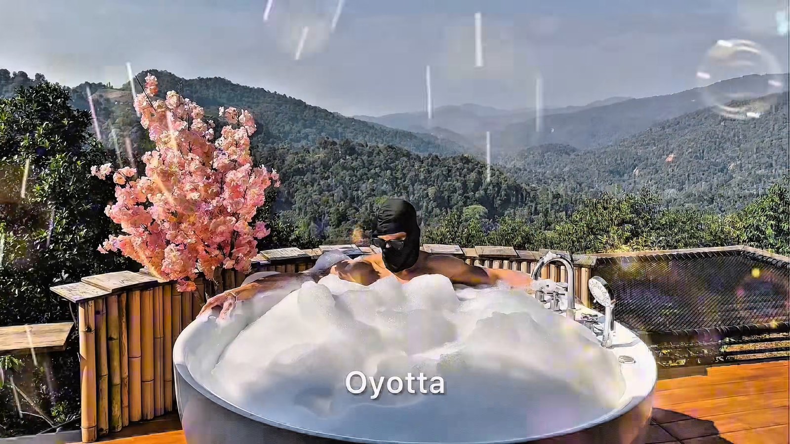 A masked figure rests in an outdoor bubble bath against a wooded mountain backdrop. Light and bubble effects and the OYOTTA title are part of the source video.
